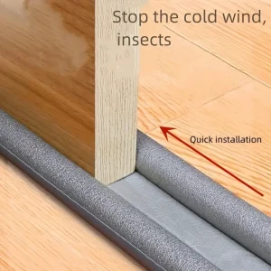 Gray foam draft stopper strip fitted under a wooden door