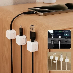 White magnetic cable clips holding charging cables on the edge of a desk