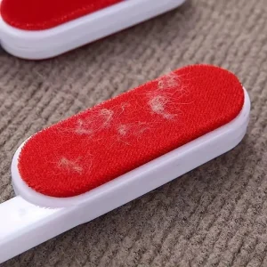 Close-up of pet fur collected on the red fabric of a reusable lint roller